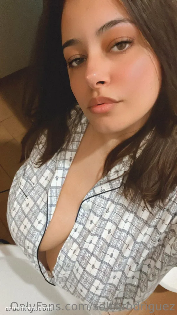 Soles Rodriguez in a white checked pyjama top taking an indoor selfie