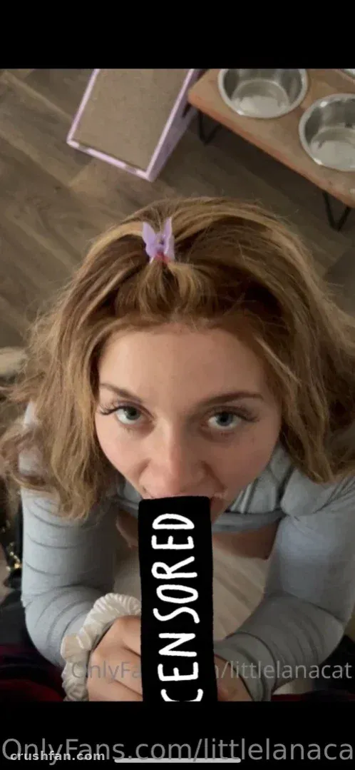 Lanacat in einem grauen Top mit lila Haarspange, die drinnen in die Kamera blickt