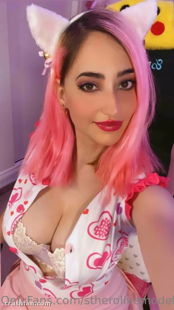Esther Olivé con cabello rosa y orejas de gato blancas en un top con estampado de corazones