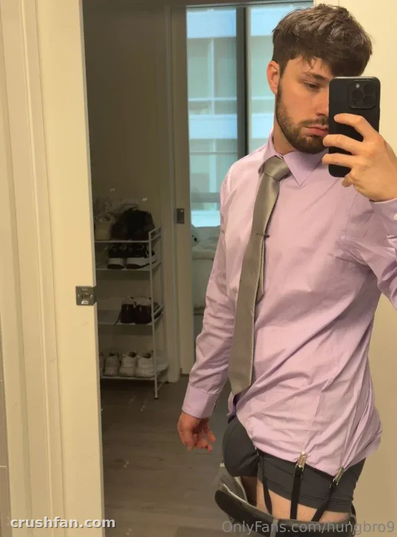 Hungbro9 prend un selfie dans le miroir en portant une chemise lavande et une cravate grise à l'intérieur.