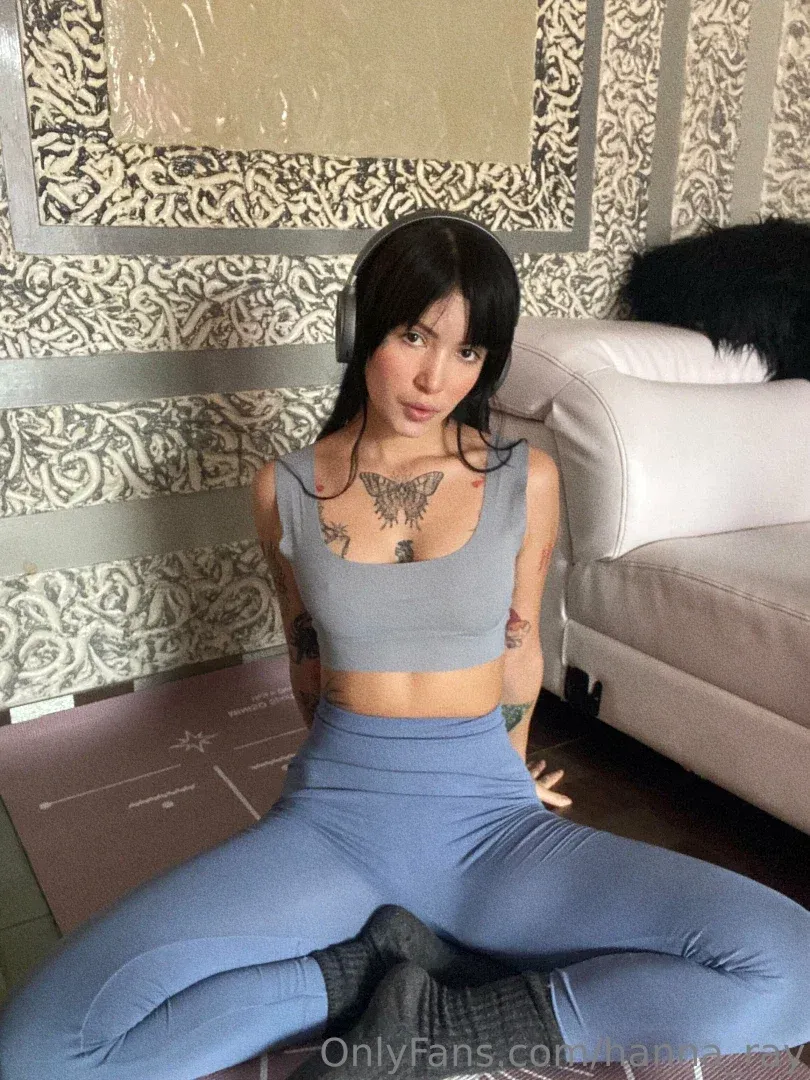 Hanna Ray VIP sitting cross-legged on a mat in a grey crop top and blue leggings
