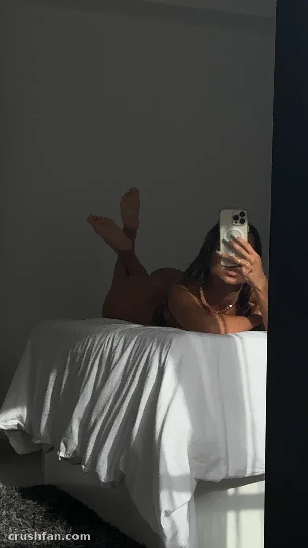 Cristina gilabert benito prenant un selfie dans le miroir allongée sur des draps blancs