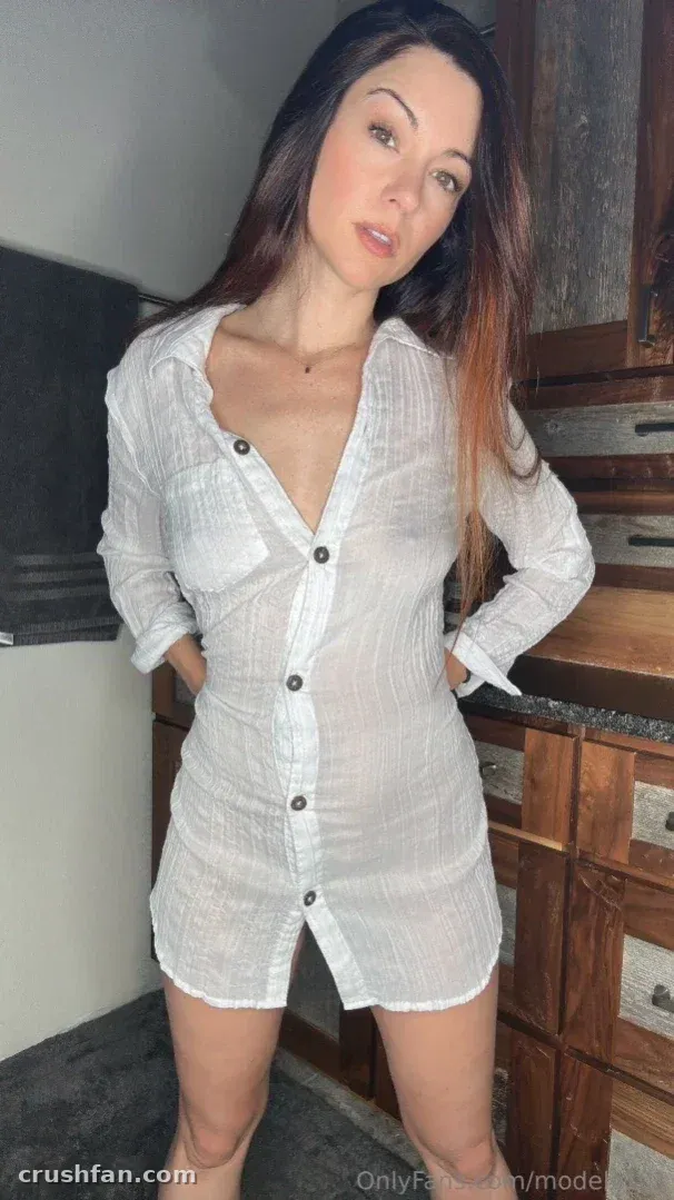 Creadora con un vestido camisero blanco de pie en una cocina rústica