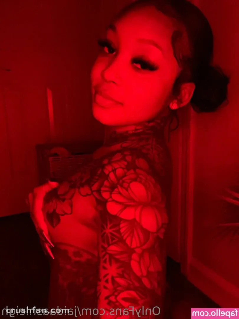 tasteofJaida in a floral lace top under deep red lighting, looking toward the camera