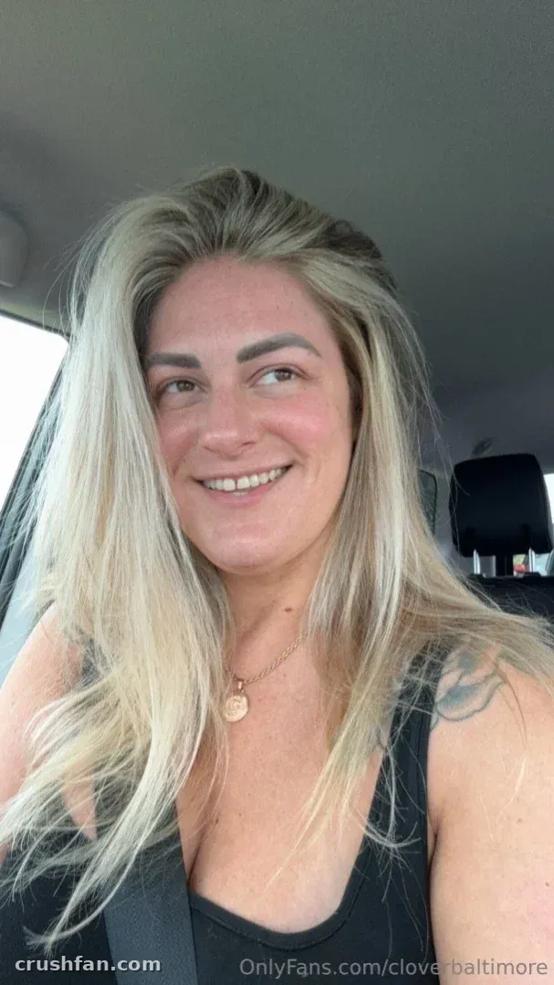 cloverbaltimore smiling in a car selfie with long blonde hair and a black top